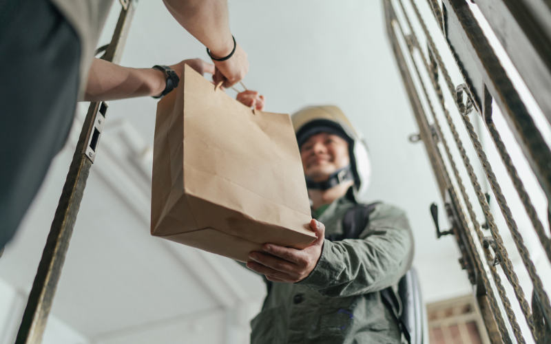 Male gig worker delivering a bag of goods
